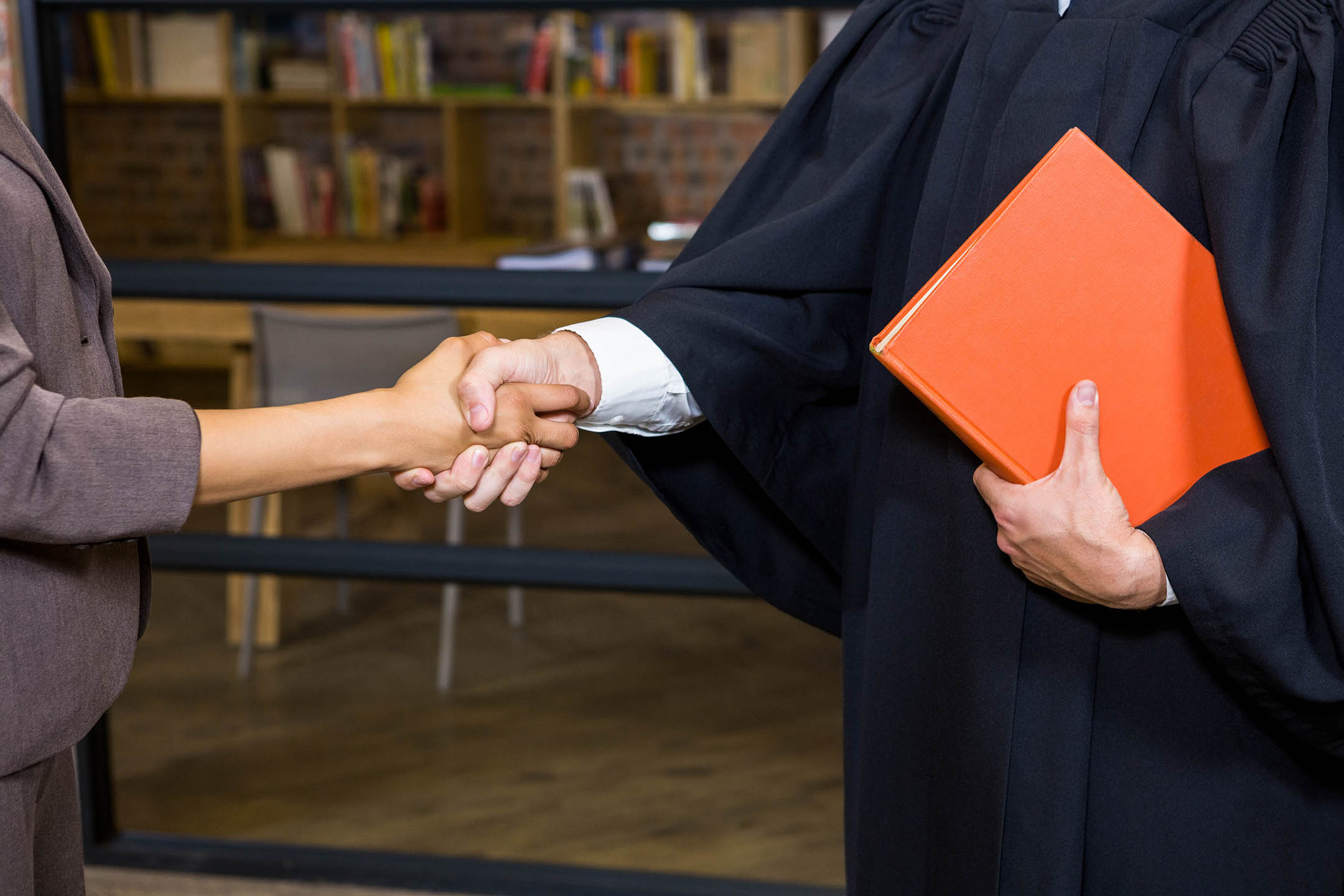 Woman shaking hands with lawyer in office